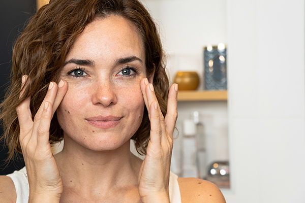 Kvinna som smörjer in sig med SPF