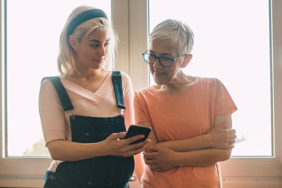 Bild på två kvinnor som tittar i en mobiltelefon