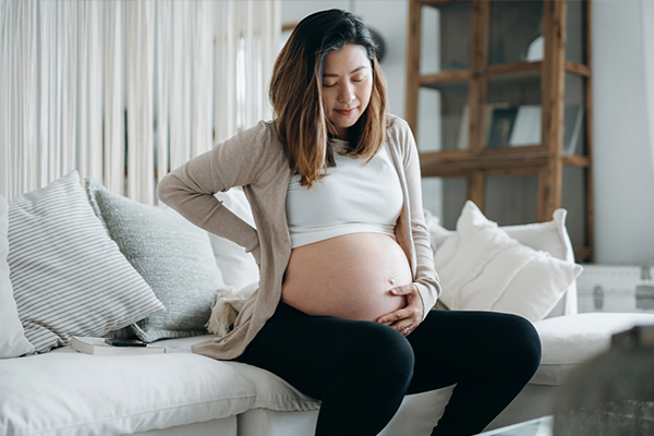 Gravid kvinna som håller på sin mage