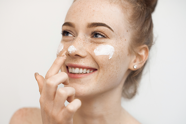 Tjej som smörjer in sin känsliga hud med lotion